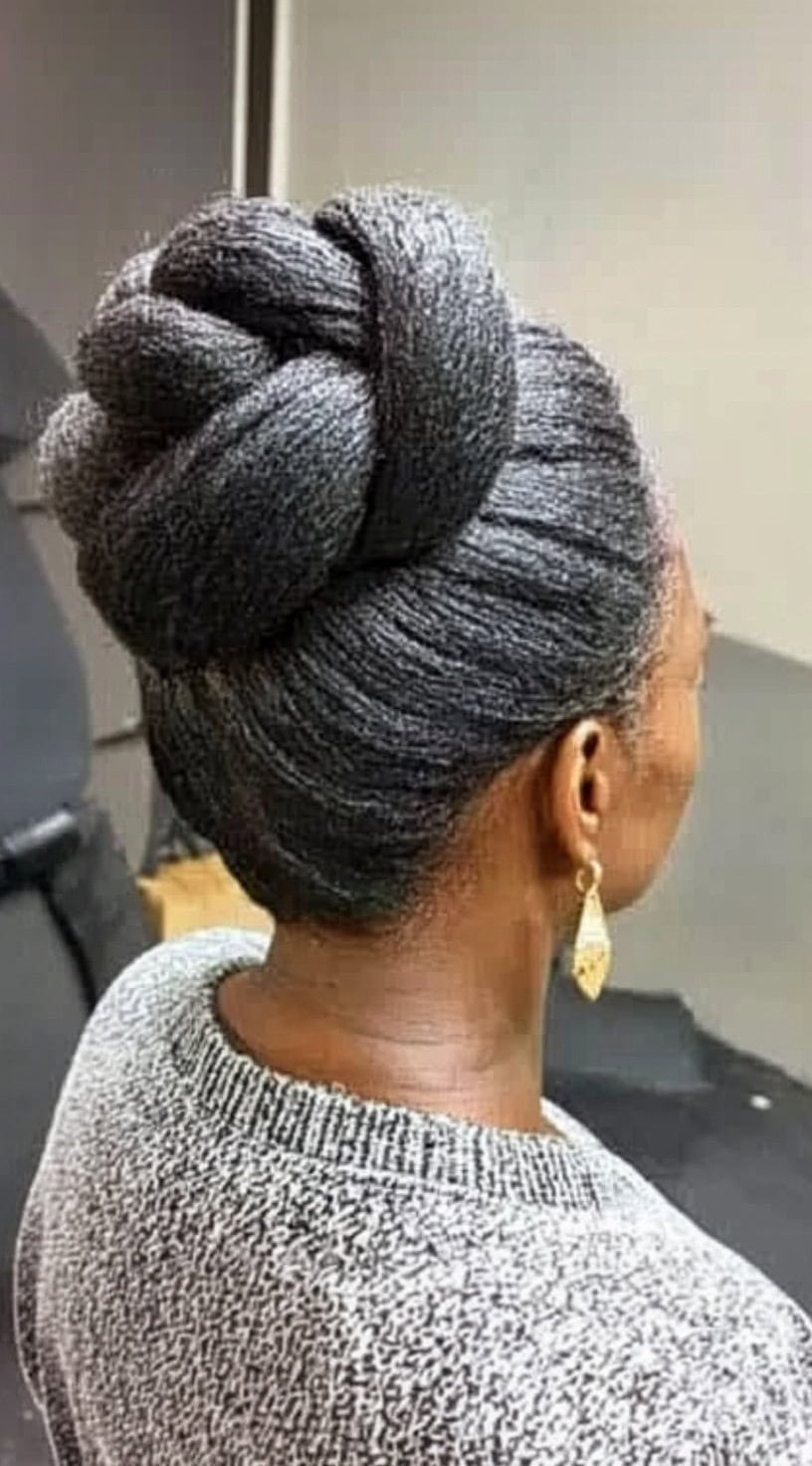 A back view of a Black woman with a textured high bun created from thick, twisted sections for an elegant and voluminous look.